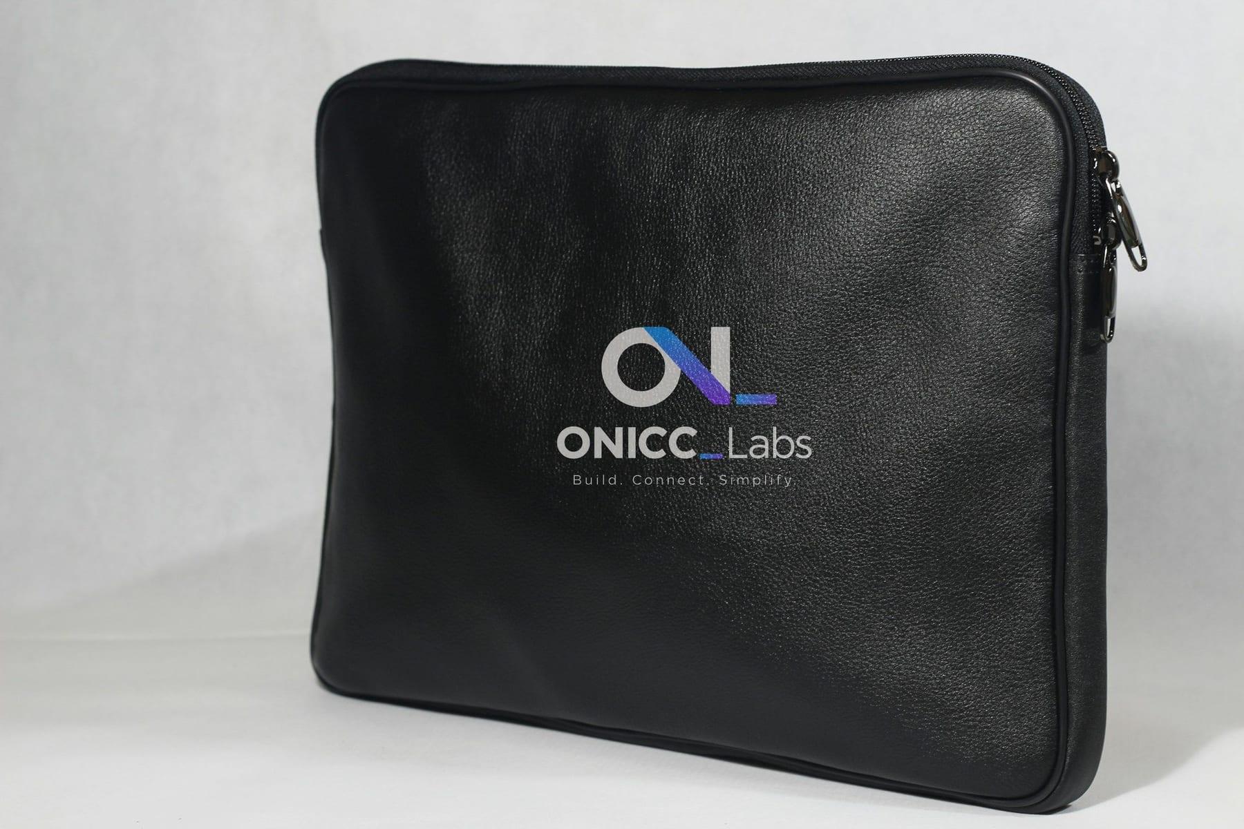 Black leather laptop sleeve printed with the ONICC Labs logo — branded laptop bag mockup