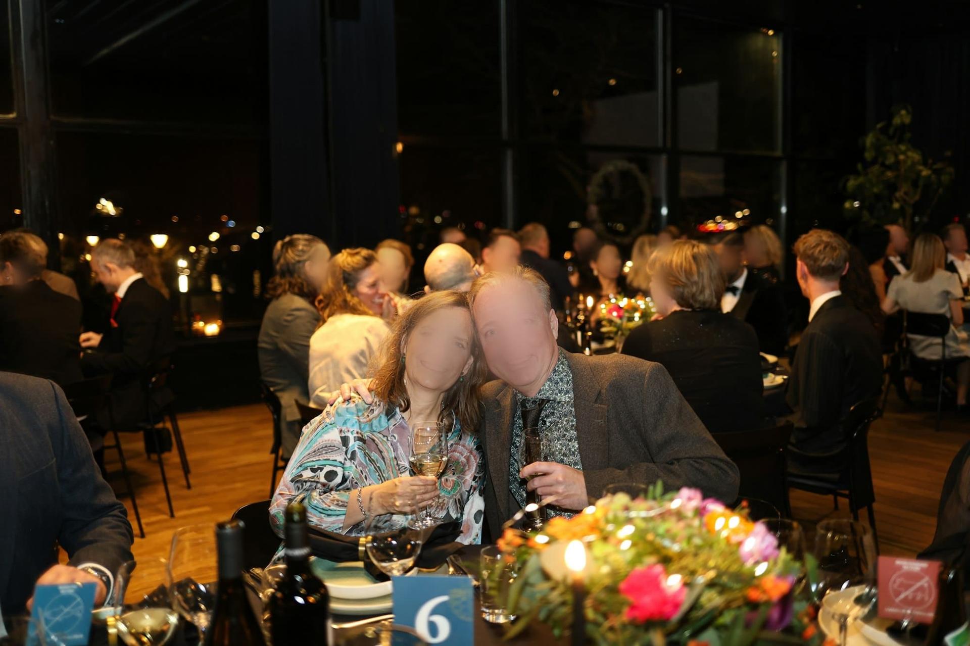 A couple smiling together at a formal celebration dinner