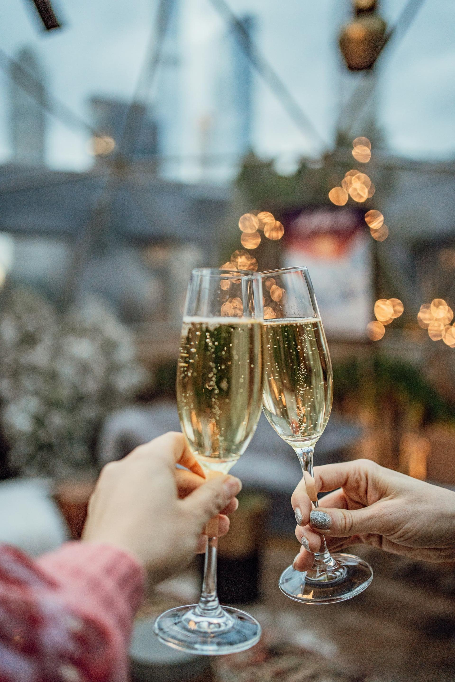 Two champagne glasses meeting in a toast