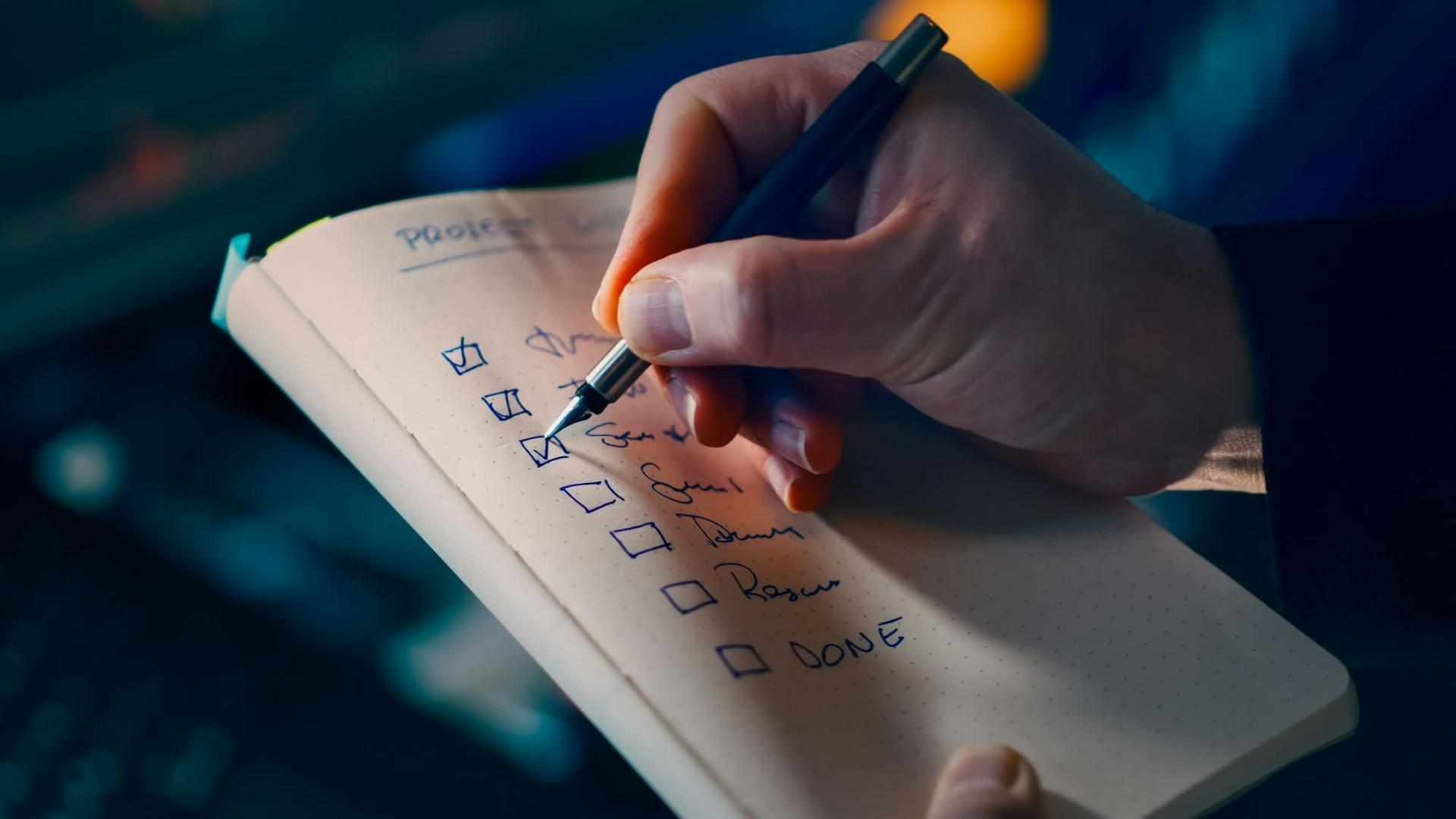 A planner ticking off items on a printed checklist