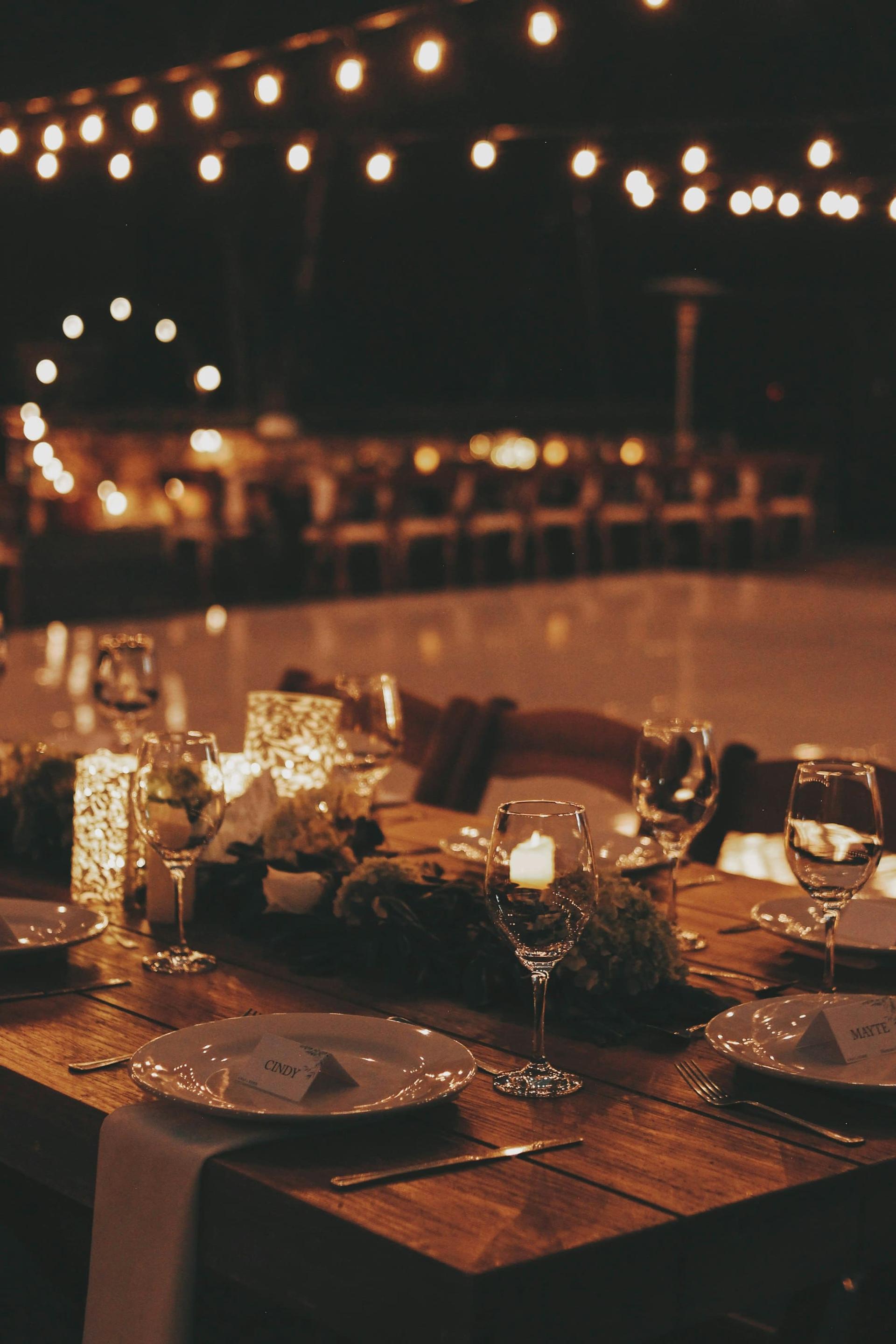 Evening reception tables beneath strings of warm festoon lights