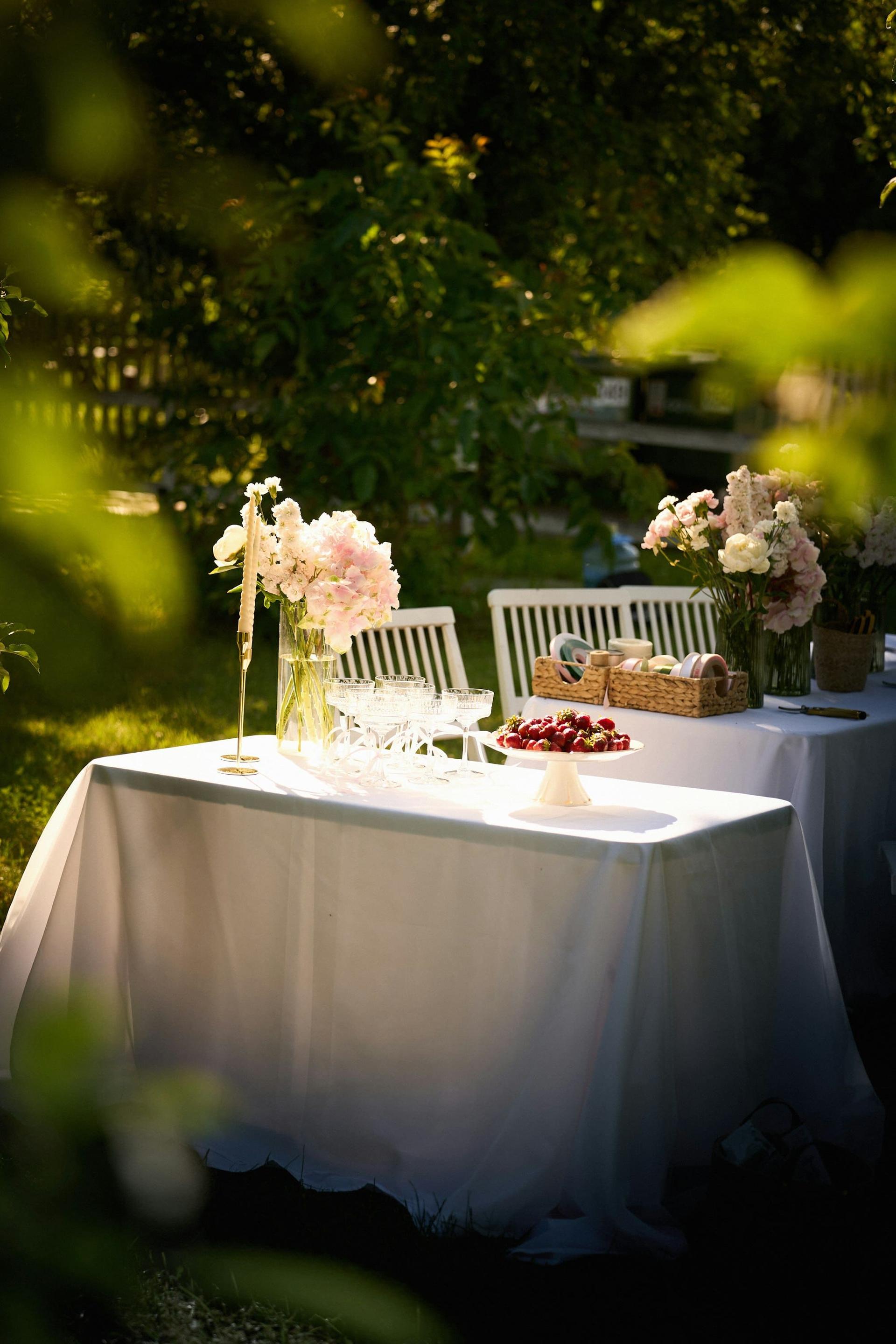 A garden celebration table set with flowers and fresh fruit