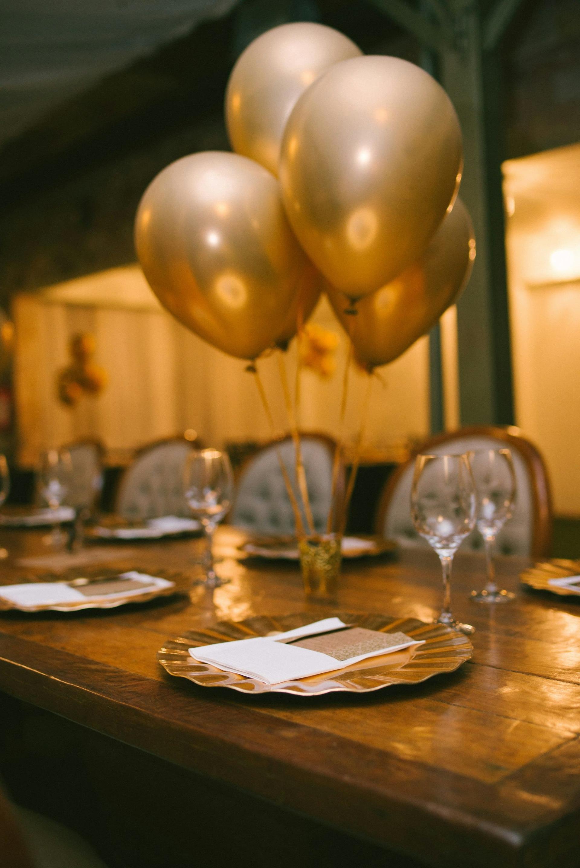 Gold balloons above a dressed table ready for a celebration